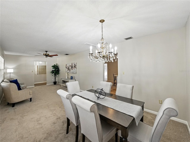 dining area featuring light carpet, a chandelier, baseboards, and ceiling fan