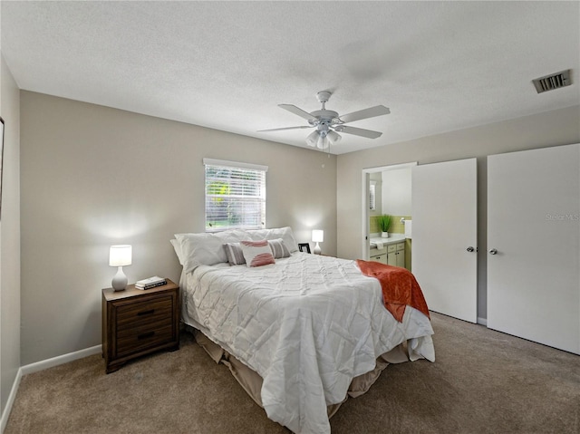 bedroom with light colored carpet, ensuite bath, baseboards, and ceiling fan