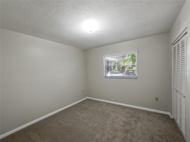 unfurnished bedroom featuring a closet, carpet floors, baseboards, and a textured ceiling