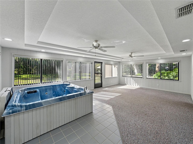 sunroom with a hot tub and a ceiling fan