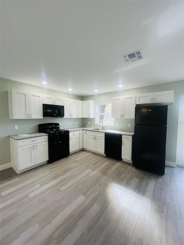 1329 Tom Watson Rd, Lakeland, FL 33801 - kitchen featuring black appliances, a sink, white cabinetry, light countertops, and recessed lighting