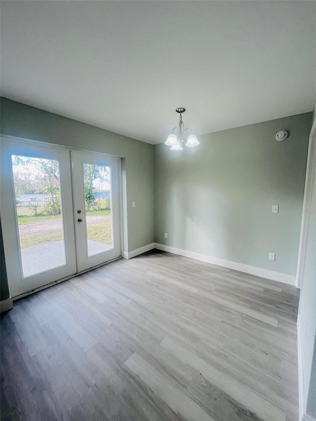 1329 Tom Watson Rd, Lakeland, FL 33801 - unfurnished dining area featuring a chandelier, wood finished floors, baseboards, and french doors