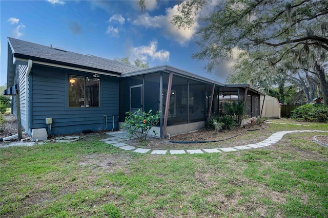 1920 Indian Trails Ct, Lakeland, FL 33813 - back of property featuring a sunroom, a lawn, and a shingled roof