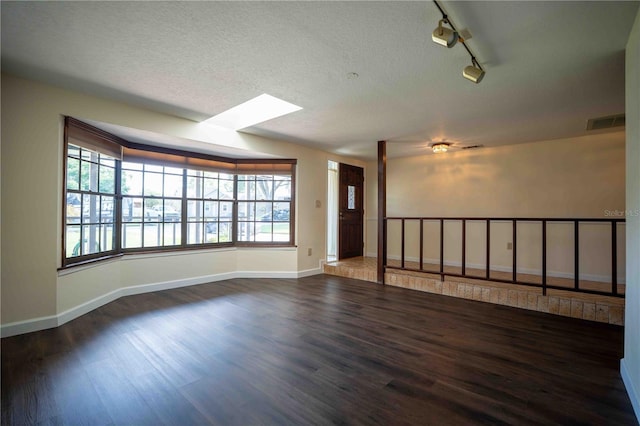 1920 Indian Trails Ct, Lakeland, FL 33813 - empty room with wood finished floors, plenty of natural light, baseboards, track lighting, and a textured ceiling