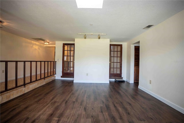 1920 Indian Trails Ct, Lakeland, FL 33813 - empty room with dark wood-style floors, baseboards, track lighting, and a textured ceiling