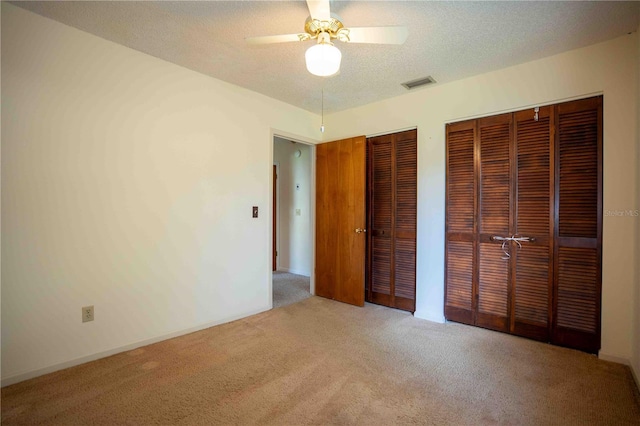 1920 Indian Trails Ct, Lakeland, FL 33813 - unfurnished bedroom with carpet, multiple closets, ceiling fan, a textured ceiling, and baseboards