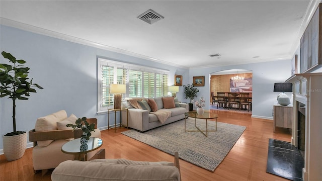 323 E Belvedere St, Lakeland, FL 33803 - living room featuring ornamental molding, arched walkways, wood finished floors, and baseboards