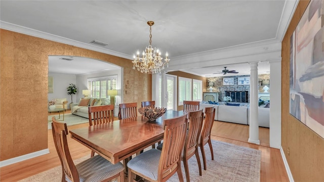 323 E Belvedere St, Lakeland, FL 33803 - dining area featuring light wood-type flooring, a fireplace, crown molding, ornate columns, and a chandelier