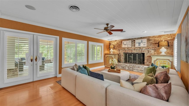 323 E Belvedere St, Lakeland, FL 33803 - living area featuring french doors, light wood finished floors, ceiling fan, a fireplace, and ornamental molding