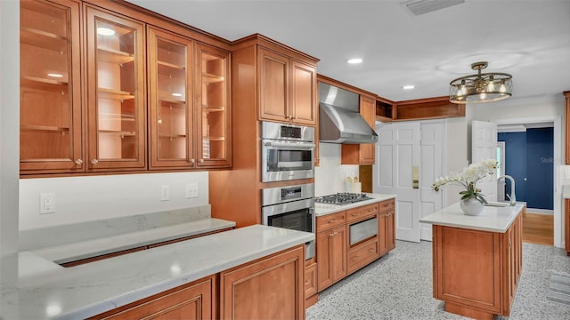 323 E Belvedere St, Lakeland, FL 33803 - kitchen featuring wall chimney exhaust hood, brown cabinetry, glass insert cabinets, recessed lighting, and a sink