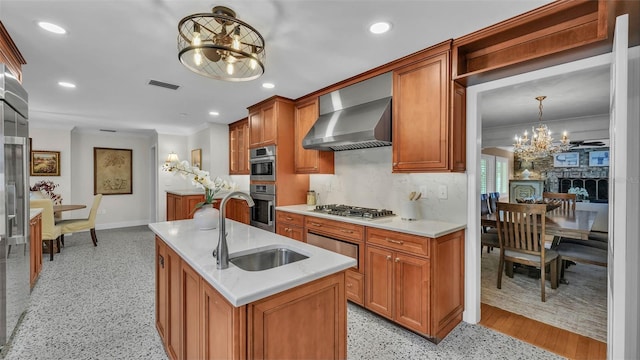 323 E Belvedere St, Lakeland, FL 33803 - kitchen featuring a chandelier, wall chimney range hood, a sink, a kitchen island with sink, and brown cabinetry