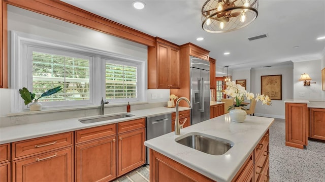 323 E Belvedere St, Lakeland, FL 33803 - kitchen featuring a sink, appliances with stainless steel finishes, brown cabinetry, crown molding, and a chandelier