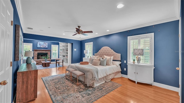 323 E Belvedere St, Lakeland, FL 33803 - bedroom with multiple windows, ornamental molding, wood finished floors, a stone fireplace, and recessed lighting