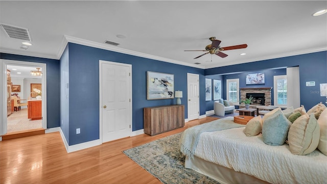 323 E Belvedere St, Lakeland, FL 33803 - bedroom featuring baseboards, crown molding, light wood-style floors, a fireplace with raised hearth, and recessed lighting