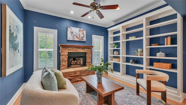 323 E Belvedere St, Lakeland, FL 33803 - living area featuring ornamental molding, a stone fireplace, ceiling fan, wood finished floors, and baseboards