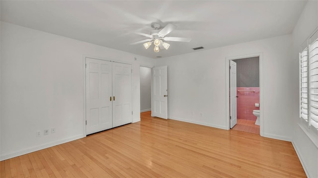 323 E Belvedere St, Lakeland, FL 33803 - unfurnished bedroom featuring light wood-type flooring, baseboards, a closet, and connected bathroom