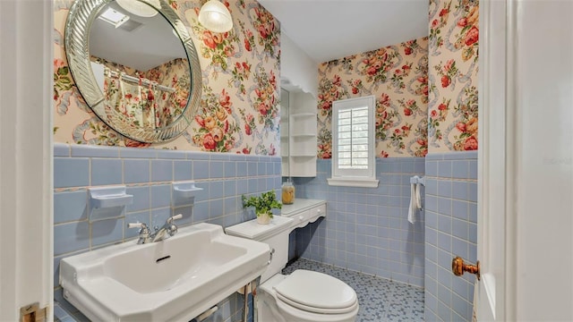 323 E Belvedere St, Lakeland, FL 33803 - full bathroom with wallpapered walls, toilet, tile walls, a wainscoted wall, and a sink