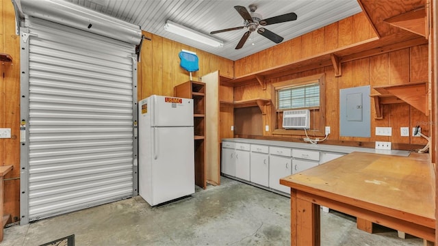 323 E Belvedere St, Lakeland, FL 33803 - kitchen featuring freestanding refrigerator, open shelves, electric panel, concrete flooring, and white cabinetry