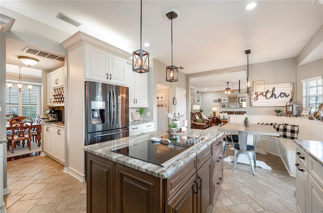 5425 Charlin Ave, Lakeland, FL 33810 - kitchen featuring black electric stovetop, stainless steel fridge with ice dispenser, a ceiling fan, a chandelier, and healthy amount of natural light