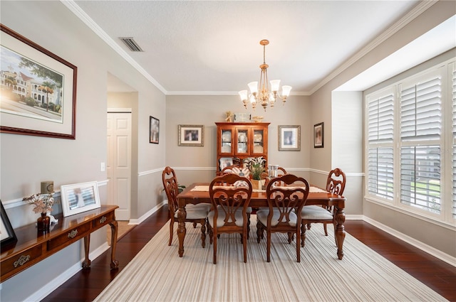 5425 Charlin Ave, Lakeland, FL 33810 - dining area with dark wood-style floors, a chandelier, crown molding, and baseboards