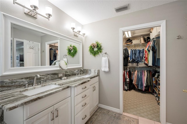 5425 Charlin Ave, Lakeland, FL 33810 - bathroom with double vanity, a spacious closet, and baseboards