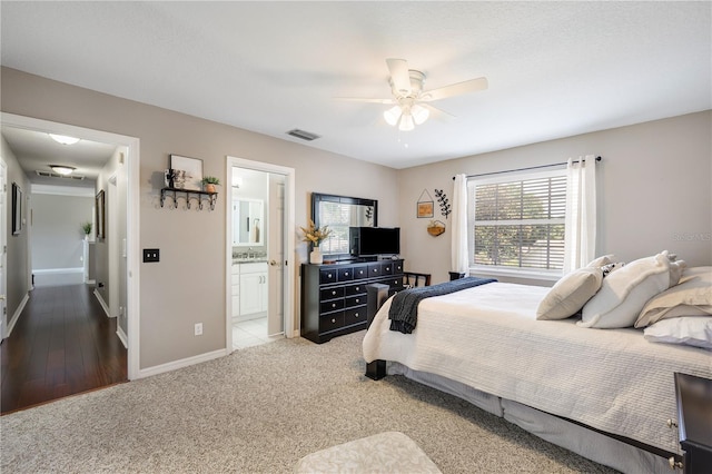 5425 Charlin Ave, Lakeland, FL 33810 - bedroom with baseboards, a sink, ensuite bath, a ceiling fan, and light carpet