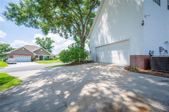 5425 Charlin Ave, Lakeland, FL 33810 - view of side of home featuring central AC unit, driveway, and an attached garage