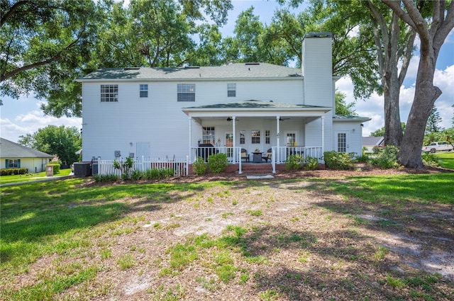 5425 Charlin Ave, Lakeland, FL 33810 - rear view of house with a chimney, central AC unit, and a lawn