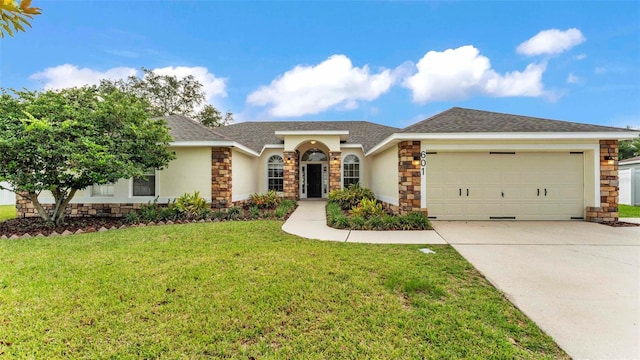 601 Pintail Cir, Auburndale, FL 33823 - view of front of property featuring an attached garage, stone siding, stucco siding, driveway, and a front yard
