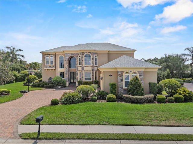 6542 Eagle Ridge Way, Lakeland, FL 33813 - view of front of property featuring stucco siding, a front lawn, stone siding, and decorative driveway