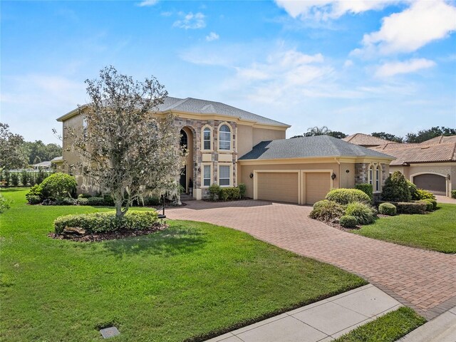 6542 Eagle Ridge Way, Lakeland, FL 33813 - view of front of property featuring a garage, decorative driveway, stucco siding, and a front yard