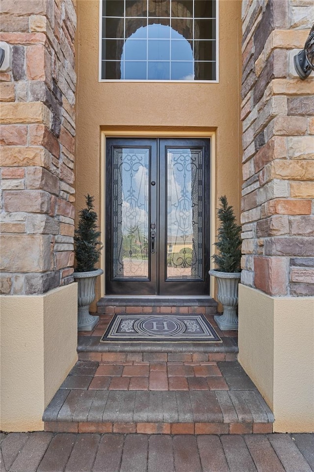 6542 Eagle Ridge Way, Lakeland, FL 33813 - entrance to property featuring french doors, stone siding, and stucco siding