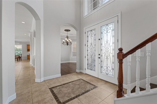 6542 Eagle Ridge Way, Lakeland, FL 33813 - foyer entrance with french doors, arched walkways, baseboards, a high ceiling, and a chandelier