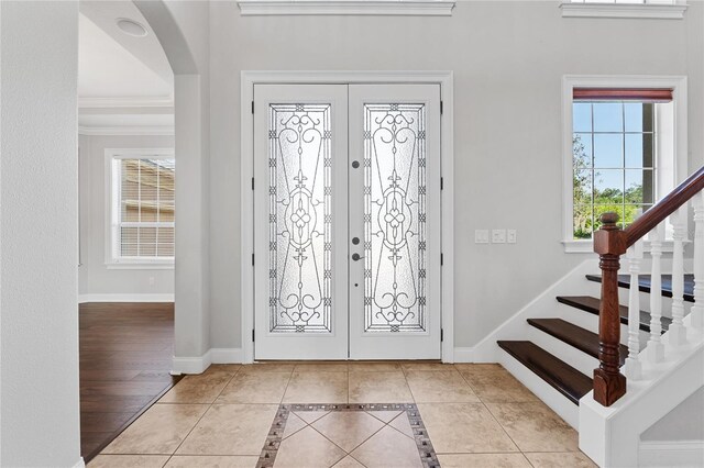 6542 Eagle Ridge Way, Lakeland, FL 33813 - foyer with french doors, light tile patterned flooring, stairs, baseboards, and crown molding