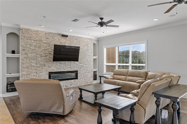 6542 Eagle Ridge Way, Lakeland, FL 33813 - living room featuring ceiling fan, built in features, a fireplace, crown molding, and wood finished floors