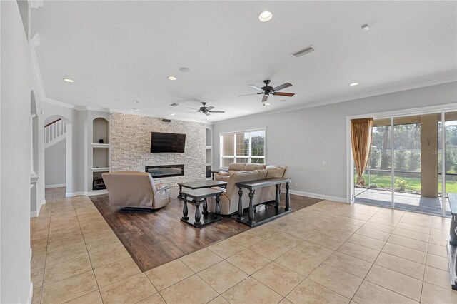 6542 Eagle Ridge Way, Lakeland, FL 33813 - living area featuring tile patterned flooring, ornamental molding, baseboards, a stone fireplace, and built in shelves
