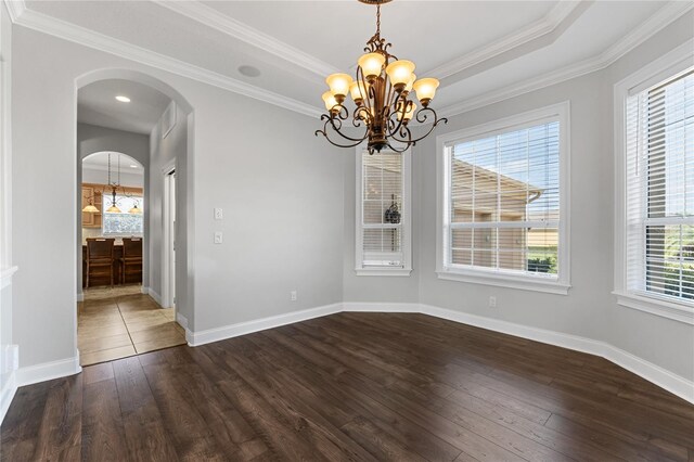 6542 Eagle Ridge Way, Lakeland, FL 33813 - unfurnished dining area featuring a chandelier, dark wood-type flooring, arched walkways, crown molding, and baseboards