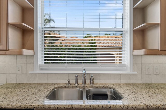 6542 Eagle Ridge Way, Lakeland, FL 33813 - kitchen view of a sink, open shelves, backsplash, and light stone counters