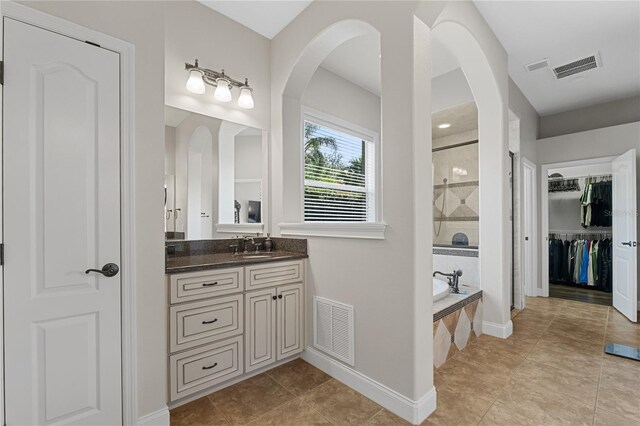 6542 Eagle Ridge Way, Lakeland, FL 33813 - full bathroom featuring a tile shower, vanity, a garden tub, baseboards, and a spacious closet