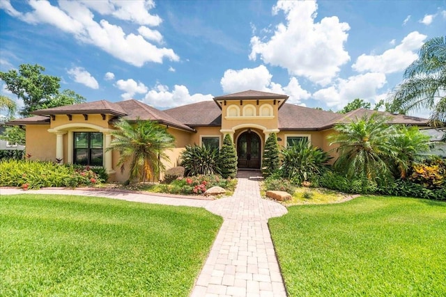 6357 Ashley Dr, Lakeland, FL 33813 - mediterranean / spanish-style home featuring stucco siding, a front lawn, and french doors