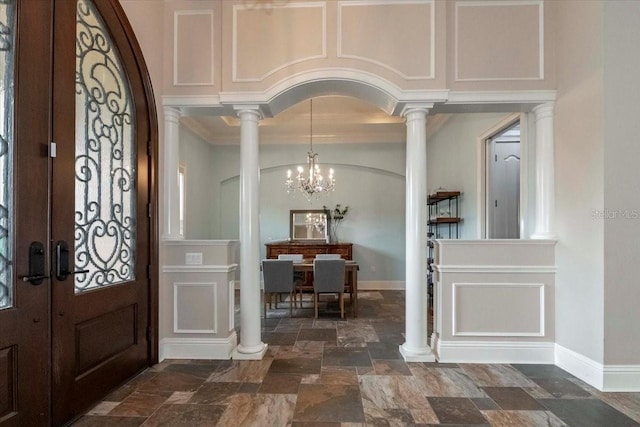 6357 Ashley Dr, Lakeland, FL 33813 - entrance foyer with stone tile flooring, ornate columns, ornamental molding, a chandelier, and baseboards