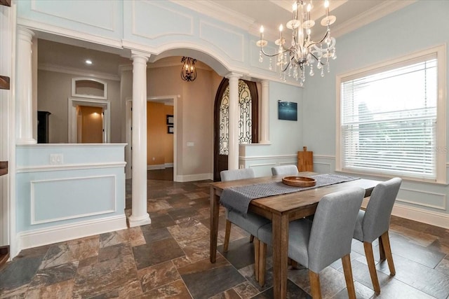 6357 Ashley Dr, Lakeland, FL 33813 - dining space with stone tile flooring, crown molding, arched walkways, a chandelier, and decorative columns
