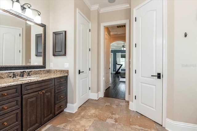 6357 Ashley Dr, Lakeland, FL 33813 - bathroom with crown molding, stone tile flooring, baseboards, vanity, and ceiling fan