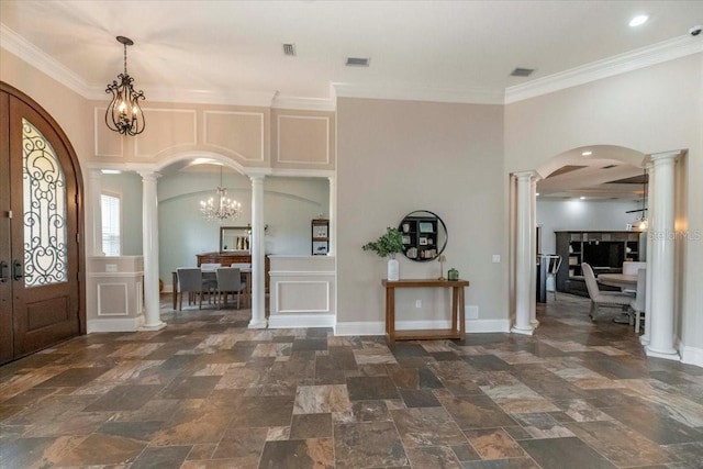 6357 Ashley Dr, Lakeland, FL 33813 - entrance foyer featuring arched walkways, ornate columns, stone finish flooring, a chandelier, and ornamental molding