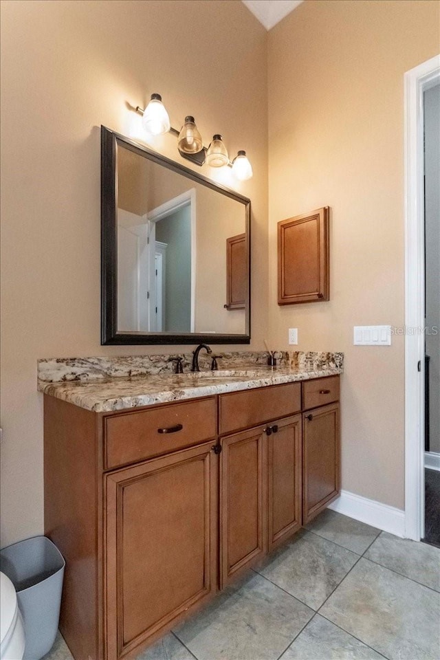 6357 Ashley Dr, Lakeland, FL 33813 - bathroom with vanity, toilet, tile patterned floors, and baseboards