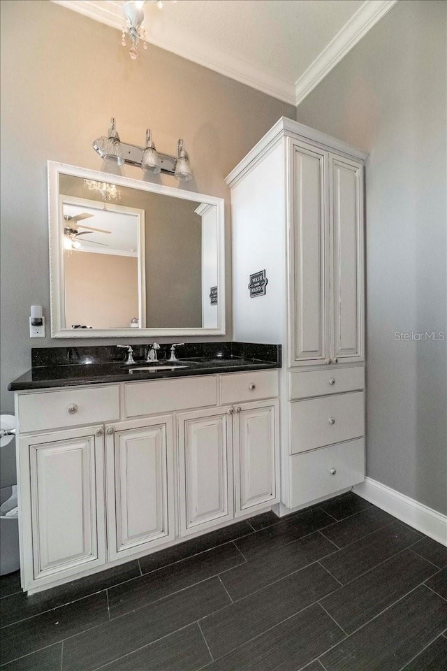 6357 Ashley Dr, Lakeland, FL 33813 - bathroom with ornamental molding, vanity, baseboards, toilet, and a ceiling fan