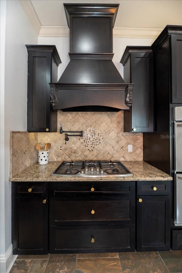6357 Ashley Dr, Lakeland, FL 33813 - kitchen featuring custom range hood, stainless steel gas cooktop, crown molding, backsplash, and dark cabinets