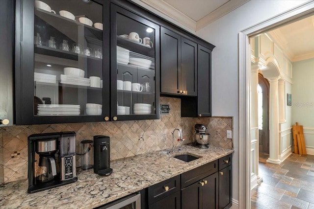 6357 Ashley Dr, Lakeland, FL 33813 - bar area featuring ornate columns, crown molding, a sink, stone tile floors, and backsplash