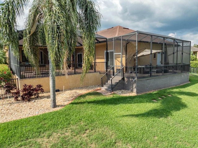 6357 Ashley Dr, Lakeland, FL 33813 - back of property with a yard, stucco siding, and a lanai