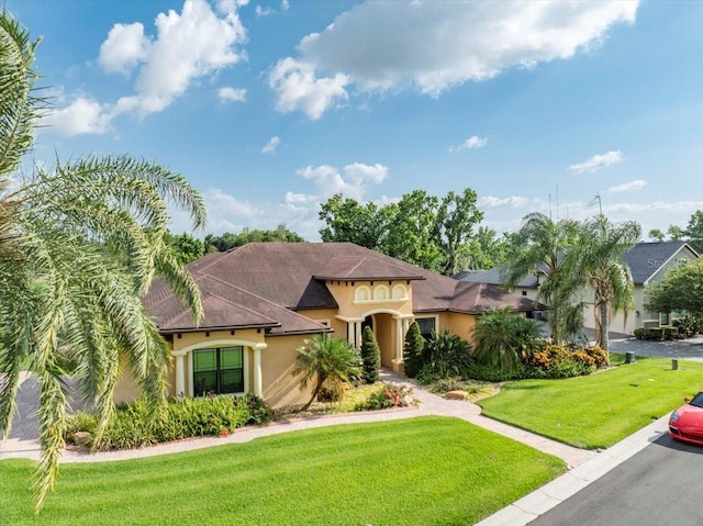 6357 Ashley Dr, Lakeland, FL 33813 - mediterranean / spanish-style home featuring stucco siding, a front lawn, and a shingled roof